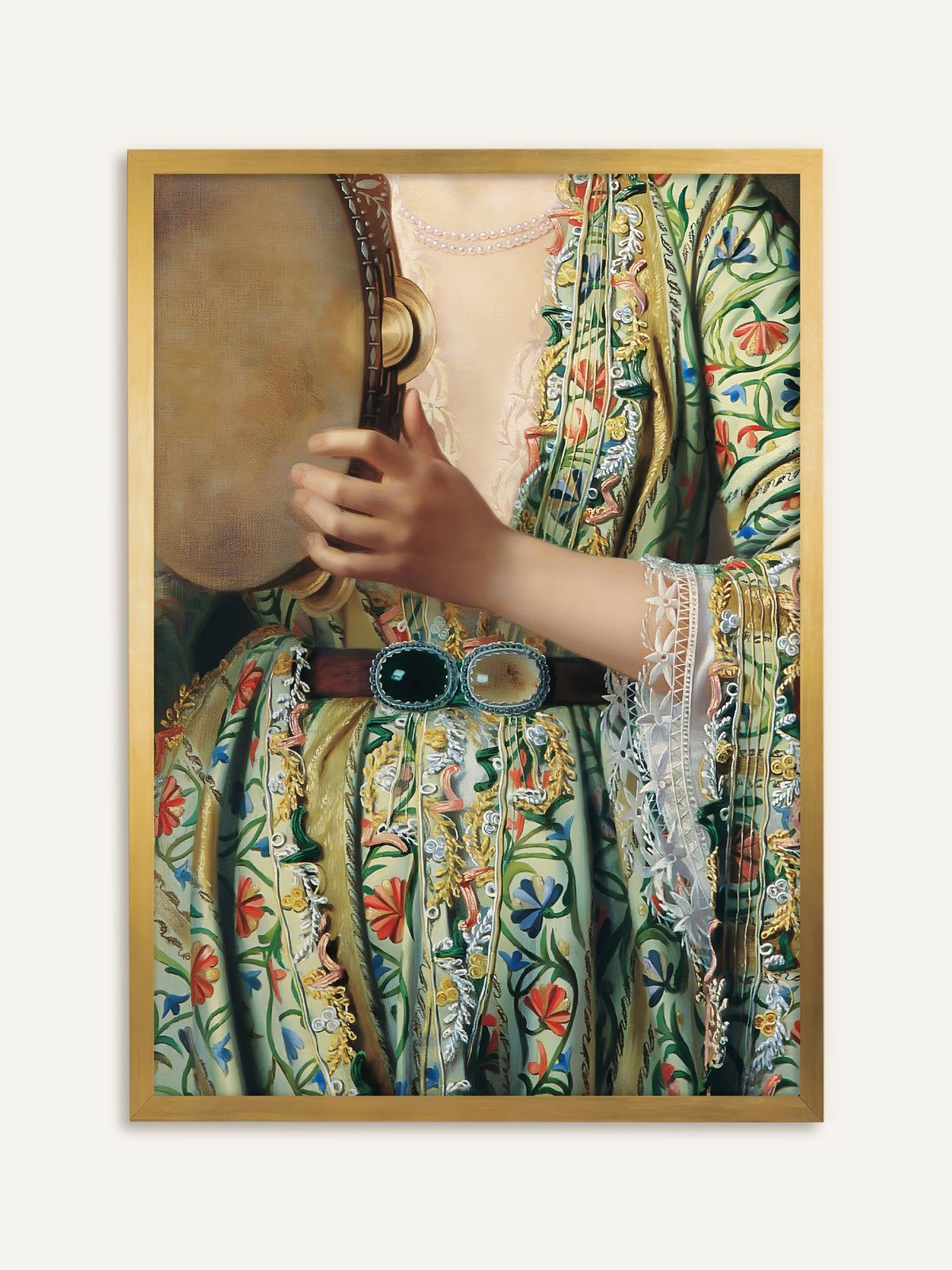 Wandbild, das als Ausschnitt eine Frau in einer hellgrünen, über und über mit bunten Blumen bestickten Robe zeigt, die ein Tamburin hält, dazu eine Spitzenmanschette, eine Perlenkette und ein Gürtel mit großen grünen Schmucksteinen. Im goldenen Rahmen wirkt das Detail wie ein antikes Gemälde. #Rahmen_Gold