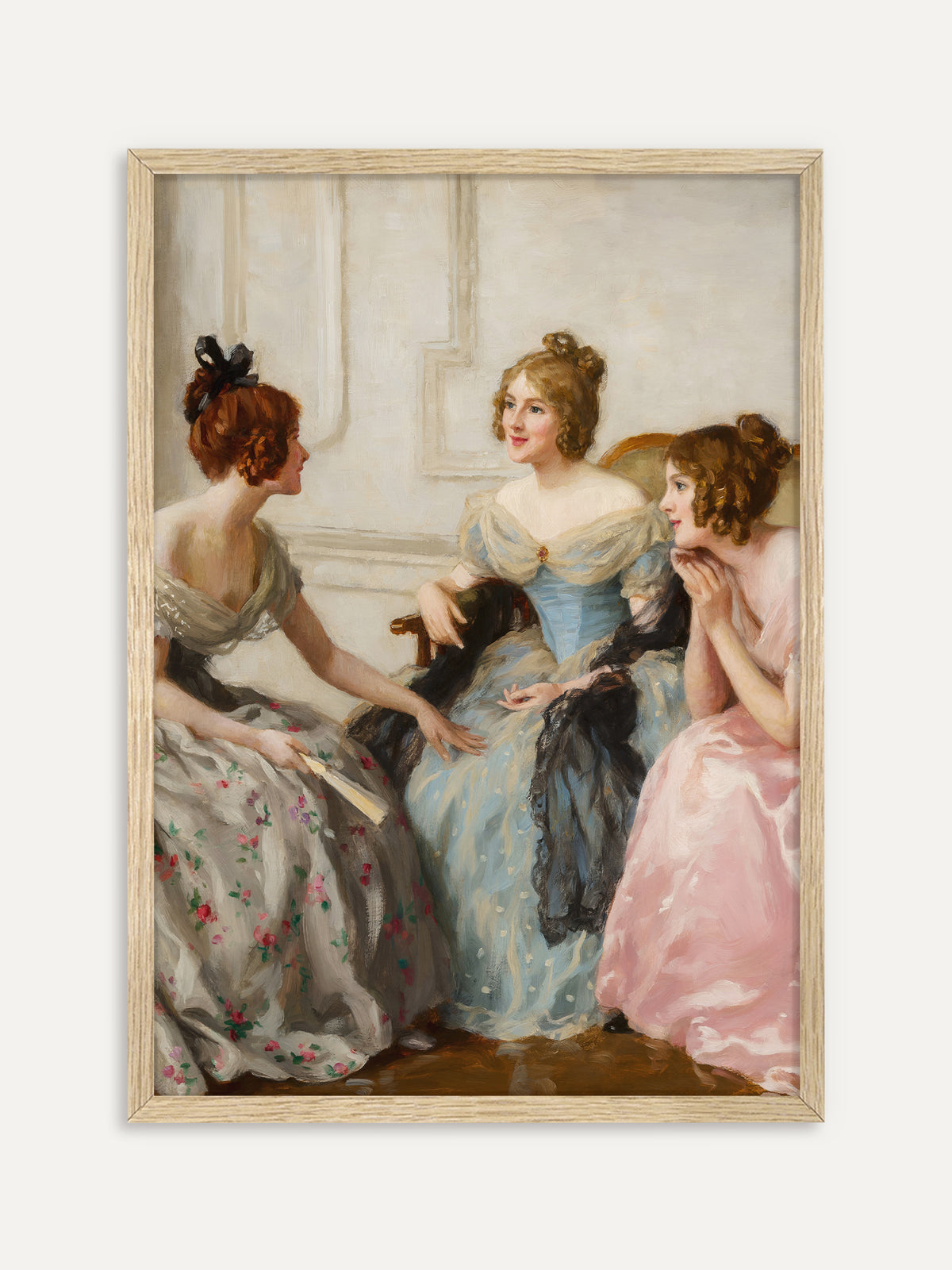 Kunstdruck, der drei junge Frauen in Abendkleidern aus Grau mit Blumen, Hellblau und Rosa zeigt, die in einem hellen Salon beieinandersitzen und sich angeregt unterhalten, eine von ihnen mit einem Fächer in der Hand. Im Rahmen aus hellem Holz wirkt die Szene leicht und hell. #Rahmen_Helles Holz