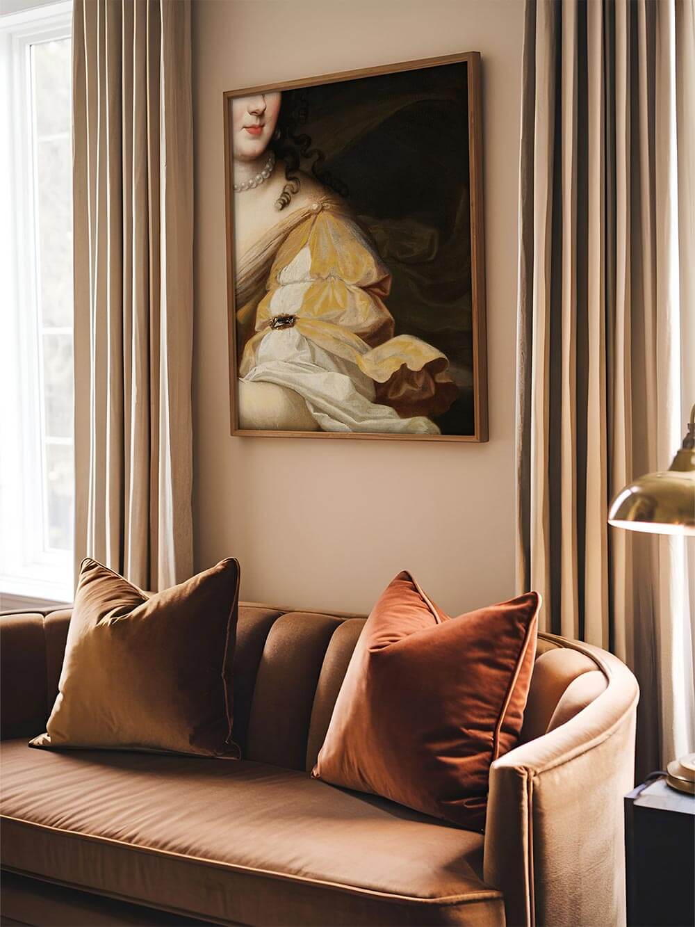 Barocker Kunstdruck mit Detail einer edlen Damenrobe in Gold und Weiß, eingerahmt über einem samtbezogenen Sofa – elegante Wandkunst mit klassischem Flair im modernen Wohnzimmer.
