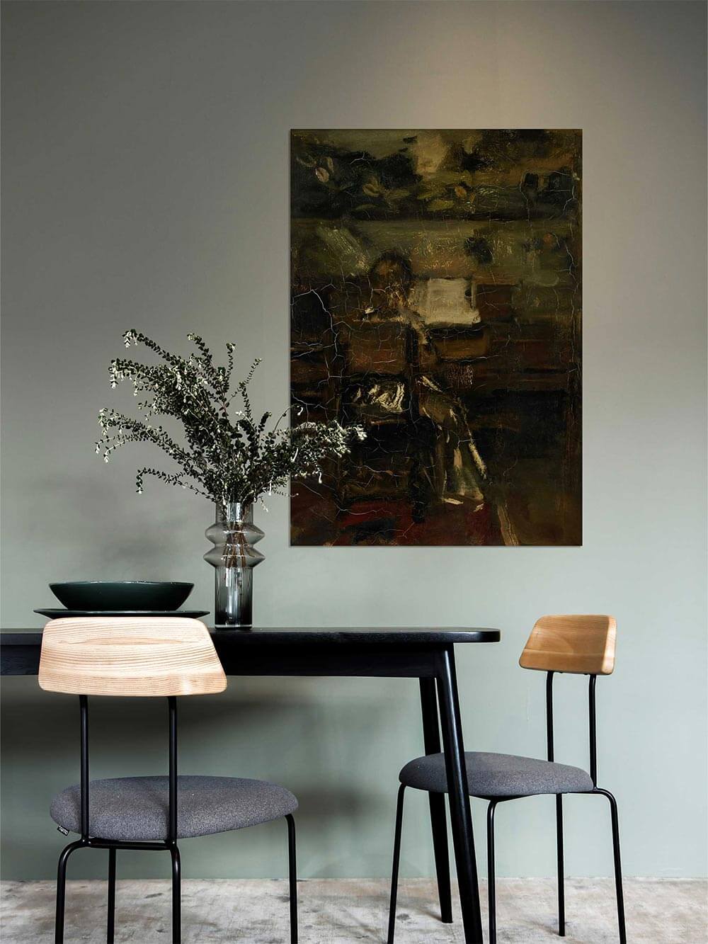 Dunkler abstrakter Kunstdruck mit warmen Brauntönen hängt über einem modernen Esstisch mit Holzstühlen und Glasvase mit Zweigen. Moody Wandbild mit vintage Charakter für moderne Esszimmerdeko.