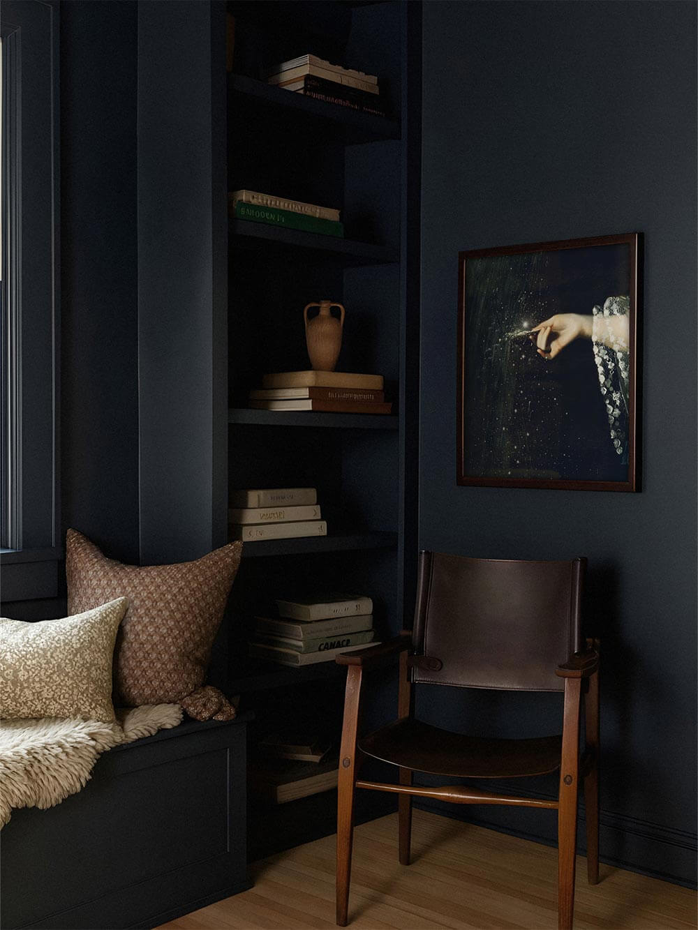 Kunstdruck mit leuchtender Hand in einem dunklen Regalzimmer mit Büchern, Holzstuhl und tiefblauen Wänden platziert. Atmosphärisches Wandbild im Dark-Academia-Stil, ideal für Leseecken, Arbeitszimmer oder moody Interiors mit Tiefe und Charakter.