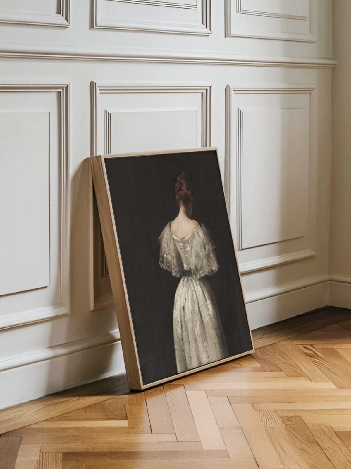 Leinwandbild mit Dame in Weiß im naturfarbenen Rahmen vor einer weißen Kassettenwand auf Fischgrätparkett aus Eiche in einem hellen Altbau