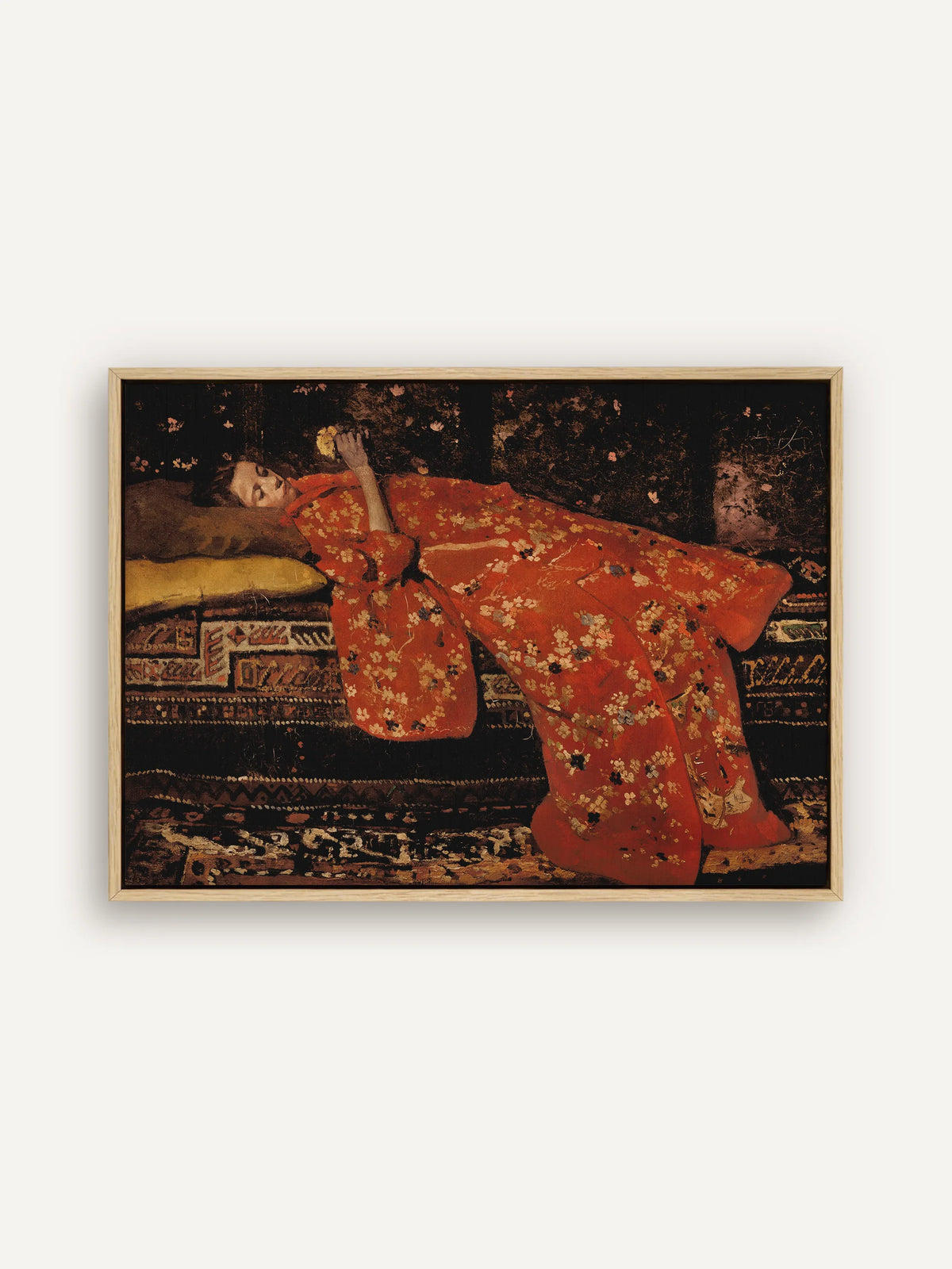 Moody Leinwandbild im Querformat im naturfarbenen Schattenfugenrahmen. Eine junge Frau im leuchtend roten Kimono mit Blütenmuster liegt auf gemusterten Teppichen vor einem fast schwarzen Hintergrund. #Rahmen_Natur