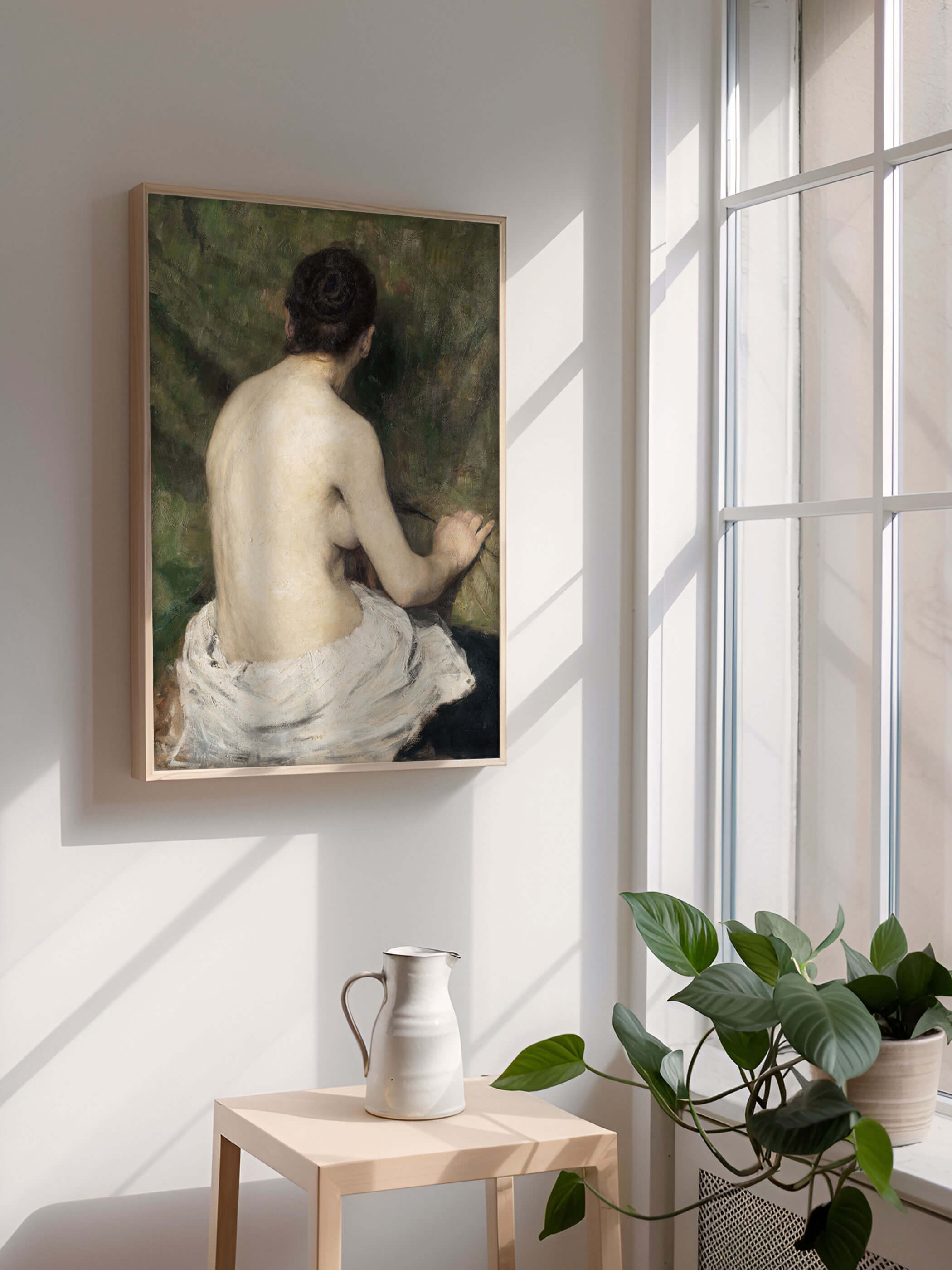 Kunstdruck des weiblichen Akts in natürlichem Licht, aufgehängt an einer weißen Wand, dekoriert in einem minimalistisch eingerichteten Raum.