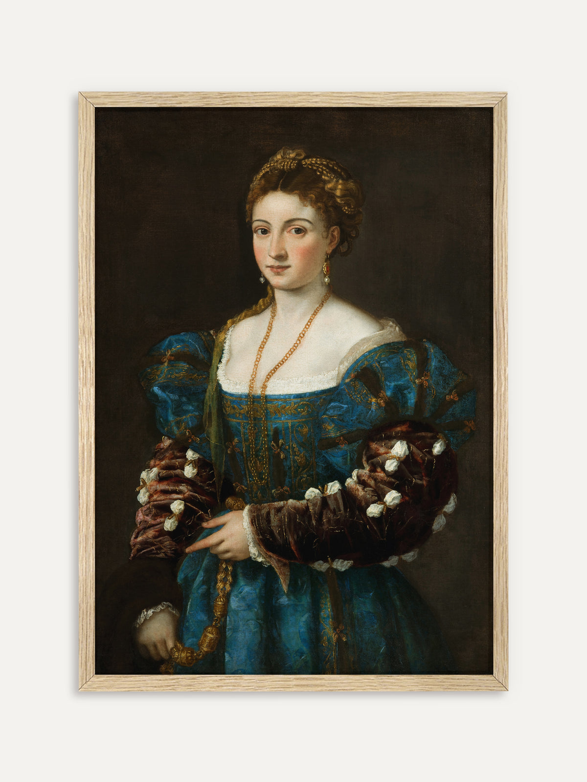 Eine junge Frau mit geflochtenem rotblondem Haar trägt ein blaues, goldbesticktes Kleid mit weinroten Samtärmeln, eine lange Goldkette und Perlenohrringe vor dunklem Hintergrund. Im Rahmen aus hellem Holz wirkt das historische Porträt leichter und passt in helle Räume. #Rahmen_Helles Holz