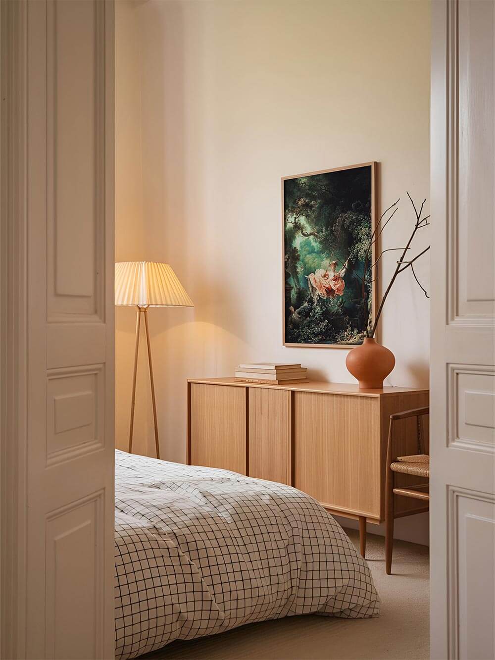 Eleganter Rokoko-Kunstdruck ‚Die Schaukel‘ als stilvolle Wanddekoration über einem Bett mit beigen und cremefarbenen Akzenten – perfekter Blickfang für klassische Interieurs.
