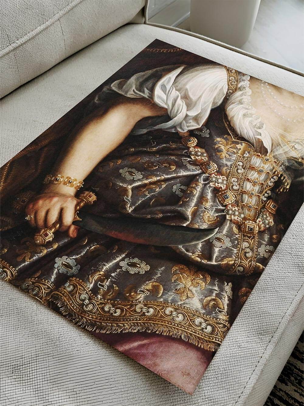 Detailreicher Kunstdruck mit barocker Eleganz: ein Ausschnitt eines historischen Porträts mit goldbesticktem Gewand und prunkvollem Schmuck, auf einem hellen Sofa liegend, das die Textur des Drucks betont.