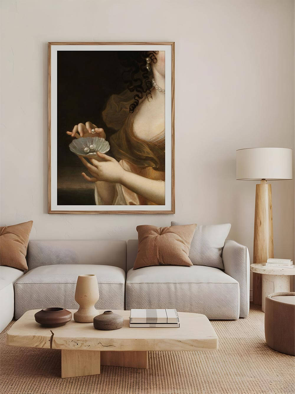 Ein kunstvoller Barock-Kunstdruck mit Muschelschale und Perlen, eingerahmt in Holz, hängt über einem modernen, neutral gehaltenen Sofa. Die warme, erdige Farbpalette harmoniert mit natürlichen Materialien wie Leinen und Holz im Interieur.