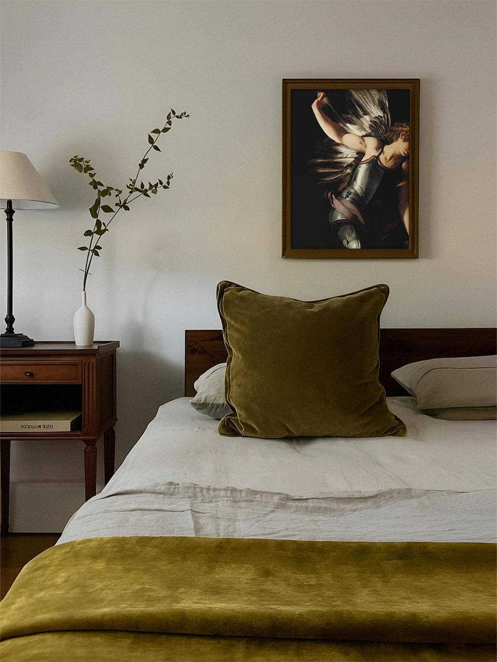 Barockes Porträt eines Engels in dunklen Tönen über Bett mit olivgrüner Bettwäsche. Das Wandbild bringt Dramatik und historische Eleganz in minimalistische Schlafzimmer im Dark-Academia-Stil.