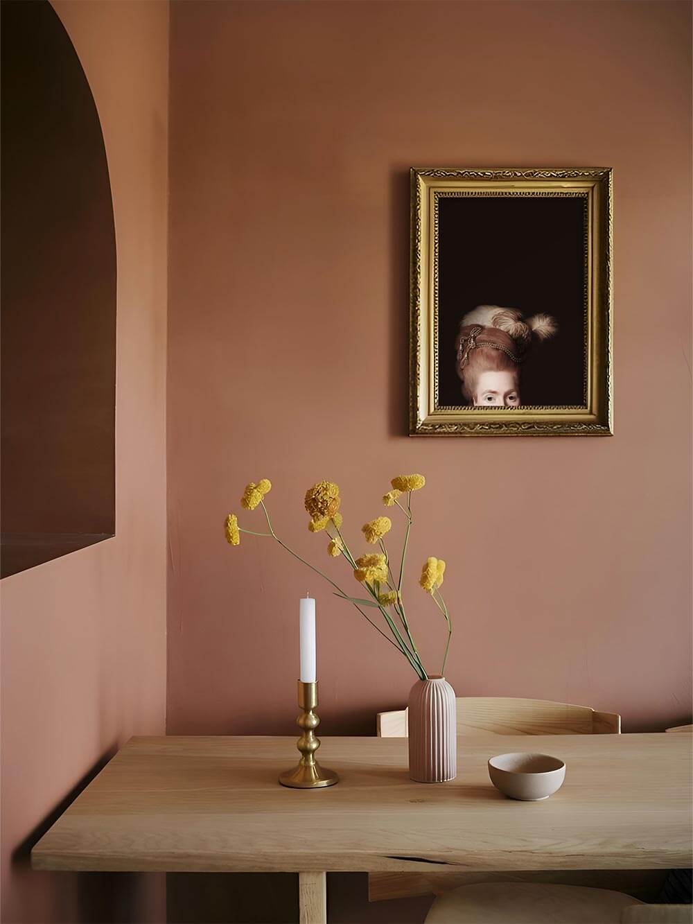 Viktorianisches Damenportrait in goldgerahmtem Kunstdruck über einem Esstisch mit warmen Terrakottawänden, gelben Trockenblumen.