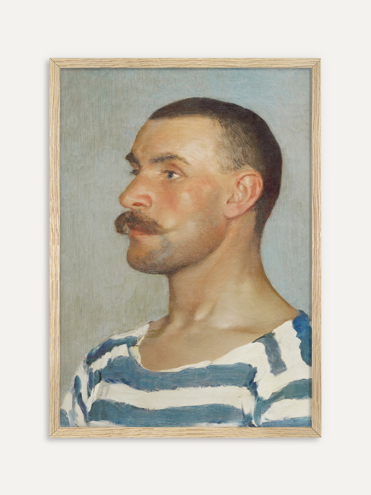 Kunstdruck, der einen Mann mit kurz geschorenem Haar und kräftigem Schnurrbart im Profil zeigt, in blau-weiß gestreiftem Shirt vor hellem, graublauem Hintergrund. Im Rahmen aus hellem Holz wirkt das maritime Vintage-Porträt frisch und leicht. #Rahmen_Helles Holz