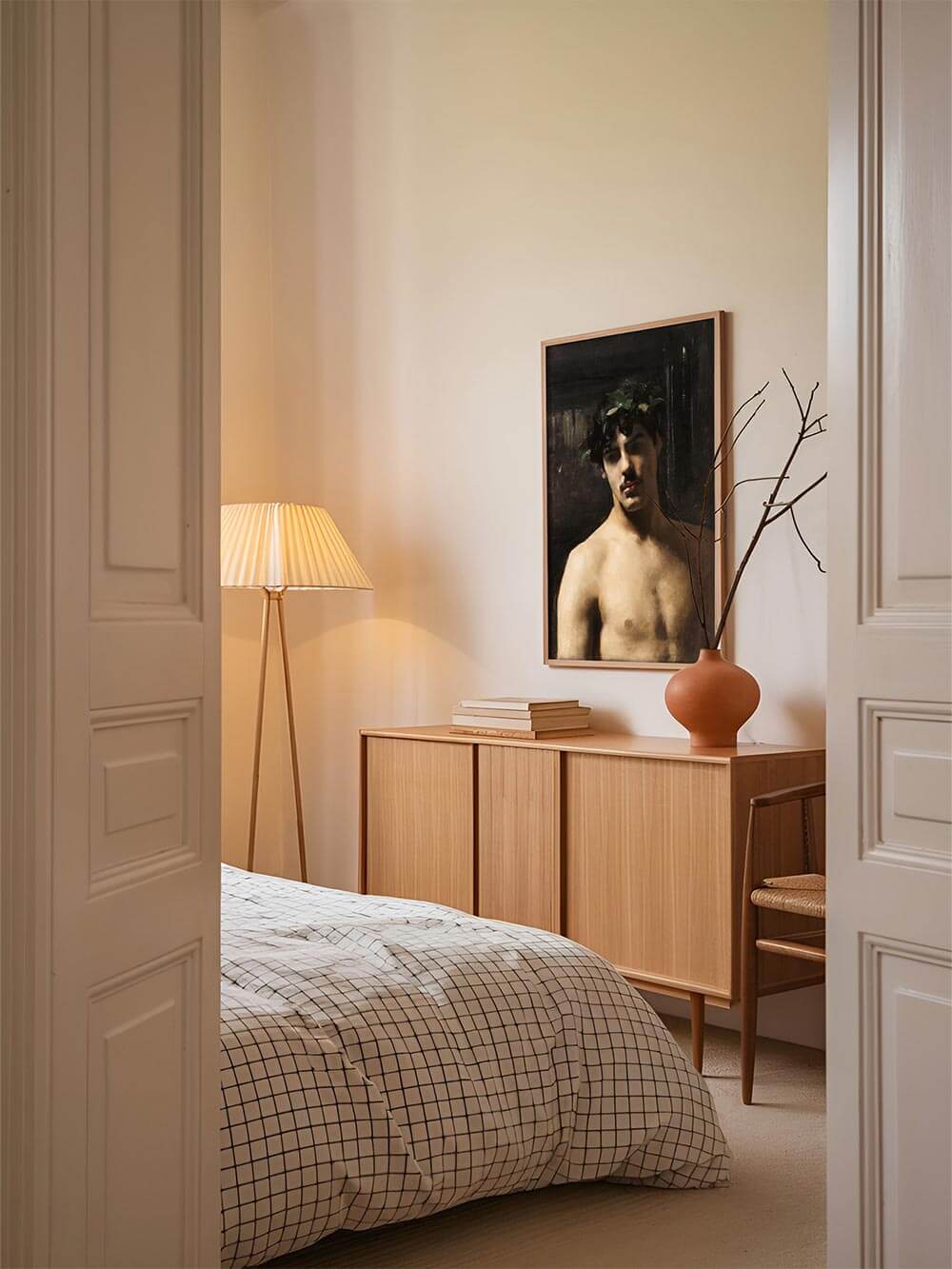 Klassisches Männerporträt mit dunklem Hintergrund, geschmackvoll gerahmt und über einer Holzkommode im Schlafzimmer arrangiert. Der Kunstdruck verleiht dem Raum eine ruhige, kunstvolle Atmosphäre mit nostalgischem Charme.