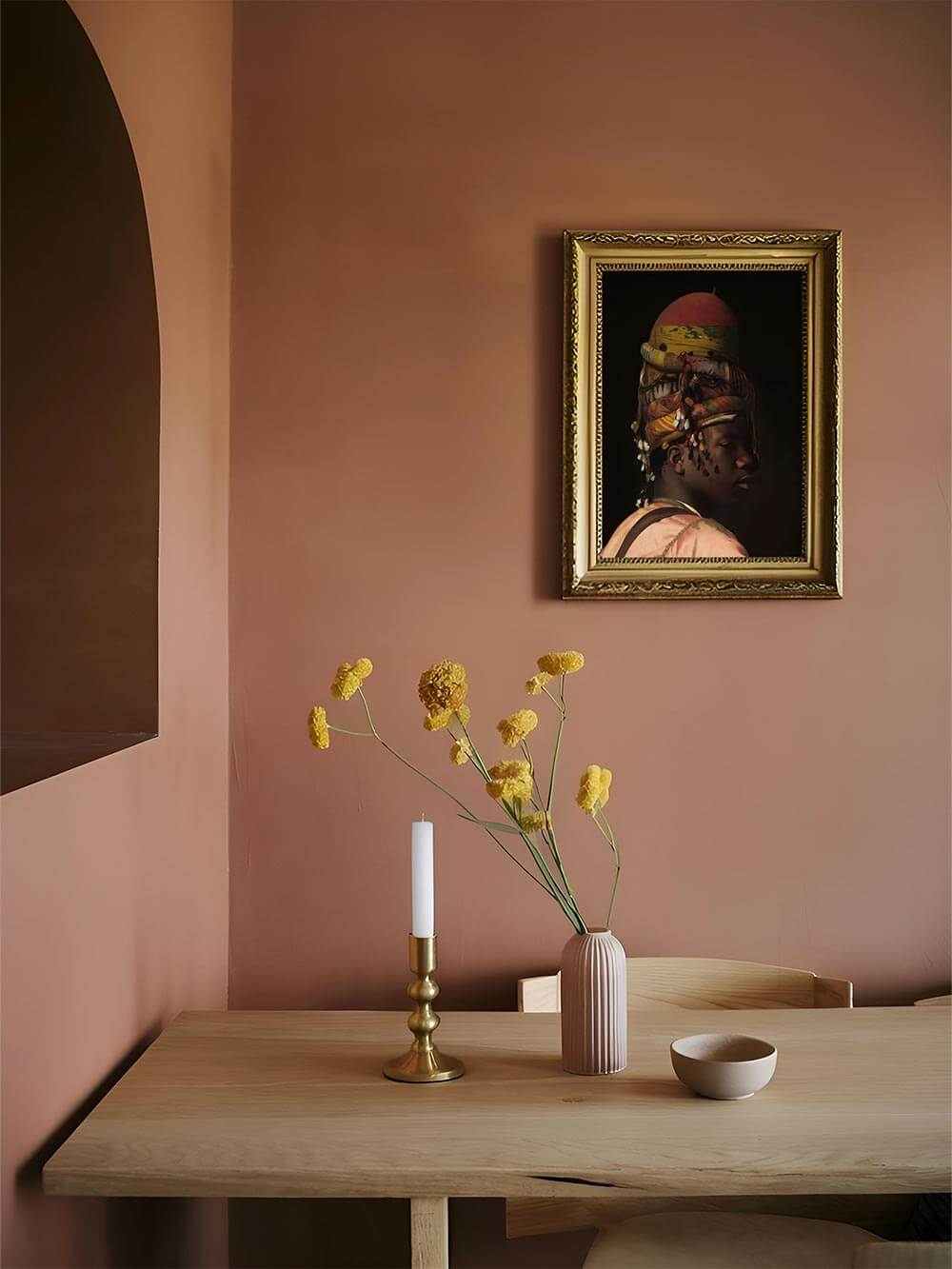Stimmungsvolles Porträt eines Mannes mit farbenprächtigem Kopfschmuck in einem klassischen Goldrahmen, elegant inszeniert an einer warmen, dunklen Wand im Esszimmer.