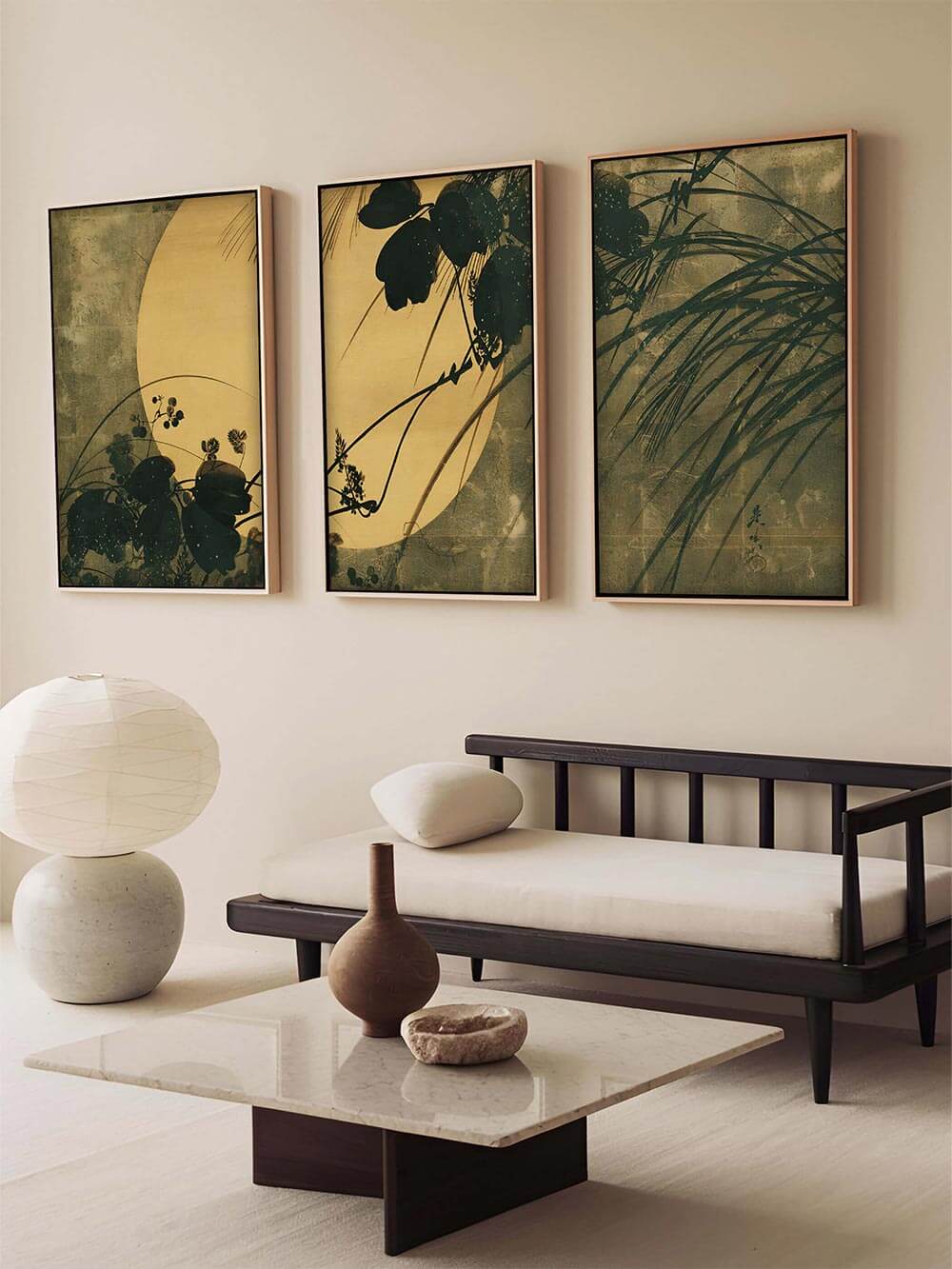 Dreiteiliges Mondlicht-Kunstdruck-Set über heller Bank mit Naturdekoration. Die Kombination aus japanischer Ästhetik, klarer Form und gedeckten Farben verleiht dem Raum meditative Gelassenheit.