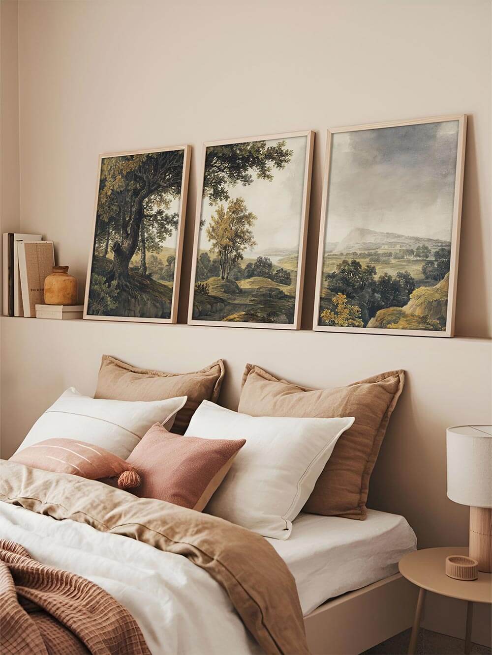 Dreiteiliges Landschafts-Wandbild über dem Bett in einem hellen Schlafzimmer, das mit natürlichen Farben, ruhiger Komposition und klassischem Stil eine entspannte Atmosphäre schafft und sich harmonisch in eine elegante Galerie-Wand einfügt.