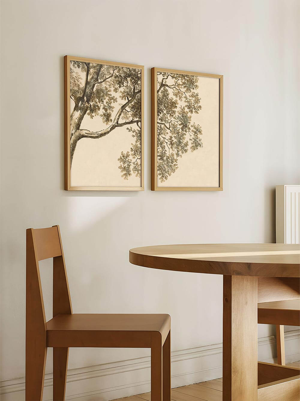 Zweiteiliges Baum-Wandbild hängt über einem Holztisch im hellen Esszimmer mit minimalistischen Möbeln. Die natürlichen Farben des Kunstdrucks ergänzen den ruhigen Raum und wirken als dezente Galerie-Wand mit botanischem Charakter.