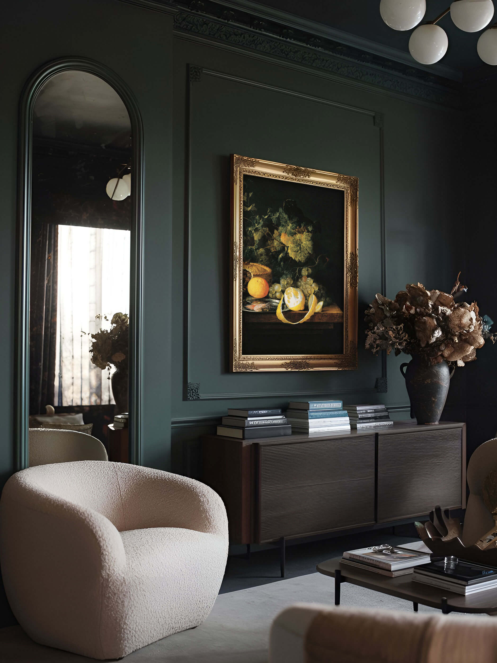 Barock-Stillleben Wandbild mit Zitrone und Weintrauben in einem goldenen Rahmen, hängend in einem eleganten, dunkelgrünen Wohnzimmer mit einem weißen Sessel und einer modernen Kommode.