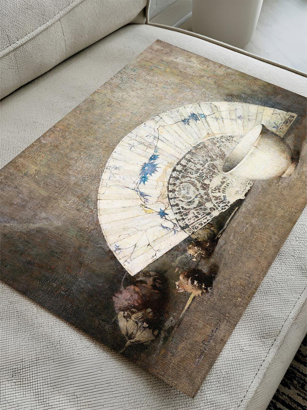 Chinoiserie Stillleben Kunstdruck, flach auf einem Sofa liegend. Die Textur der Leinwand und die zarten Farbschattierungen betonen die raffinierte Darstellung eines Fächers, einer Porzellanschale und getrockneter Blüten.