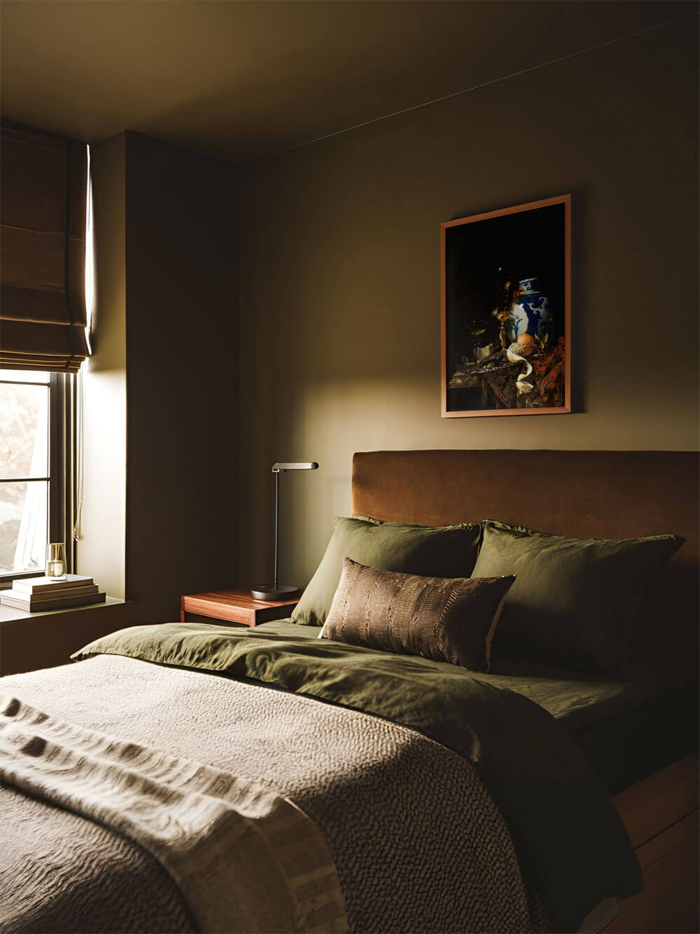 Barockes Stillleben mit Zitrone, Vase und Kelch, eingerahmt über einem Bett in einem gemütlich gestalteten, dunkelgrünen Schlafzimmer.