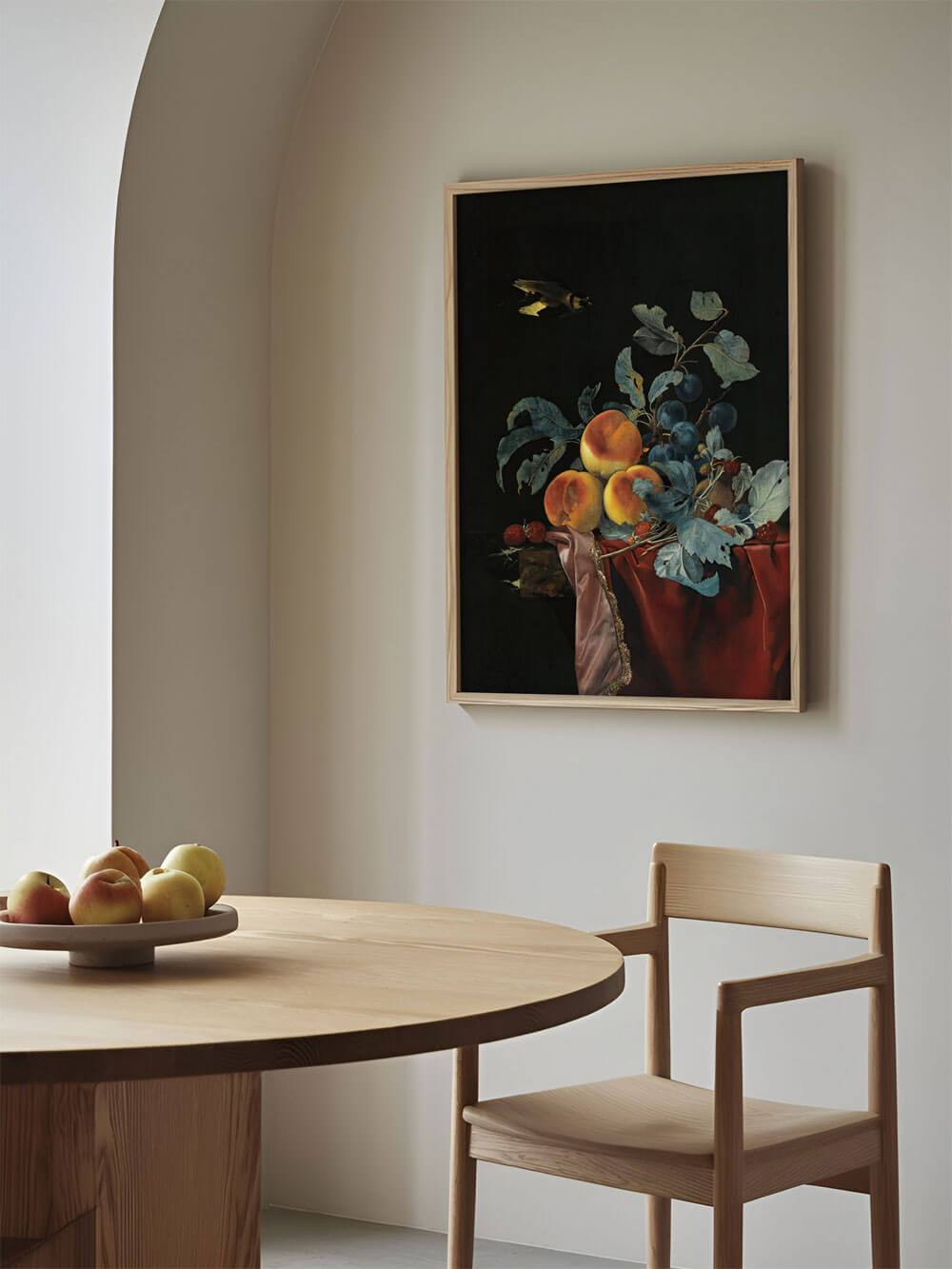 Barockes Stillleben mit Pfirsichen und Trauben, gerahmt an einer hellen Wand über einem runden Holztisch mit frischen Äpfeln. Klassisches Kunstwerk als Blickfang in einem minimalistischen Esszimmer.