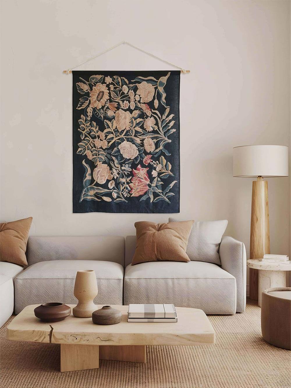 Textiler Wandbehang mit floraler Illustration ergänzt ein modernes Wohnzimmer mit Sofa, Holz- und Keramikelementen. Das Wandbild bringt Struktur, Tiefe und einen dezenten Vintage-Akzent in eine zeitlose Wohnumgebung.