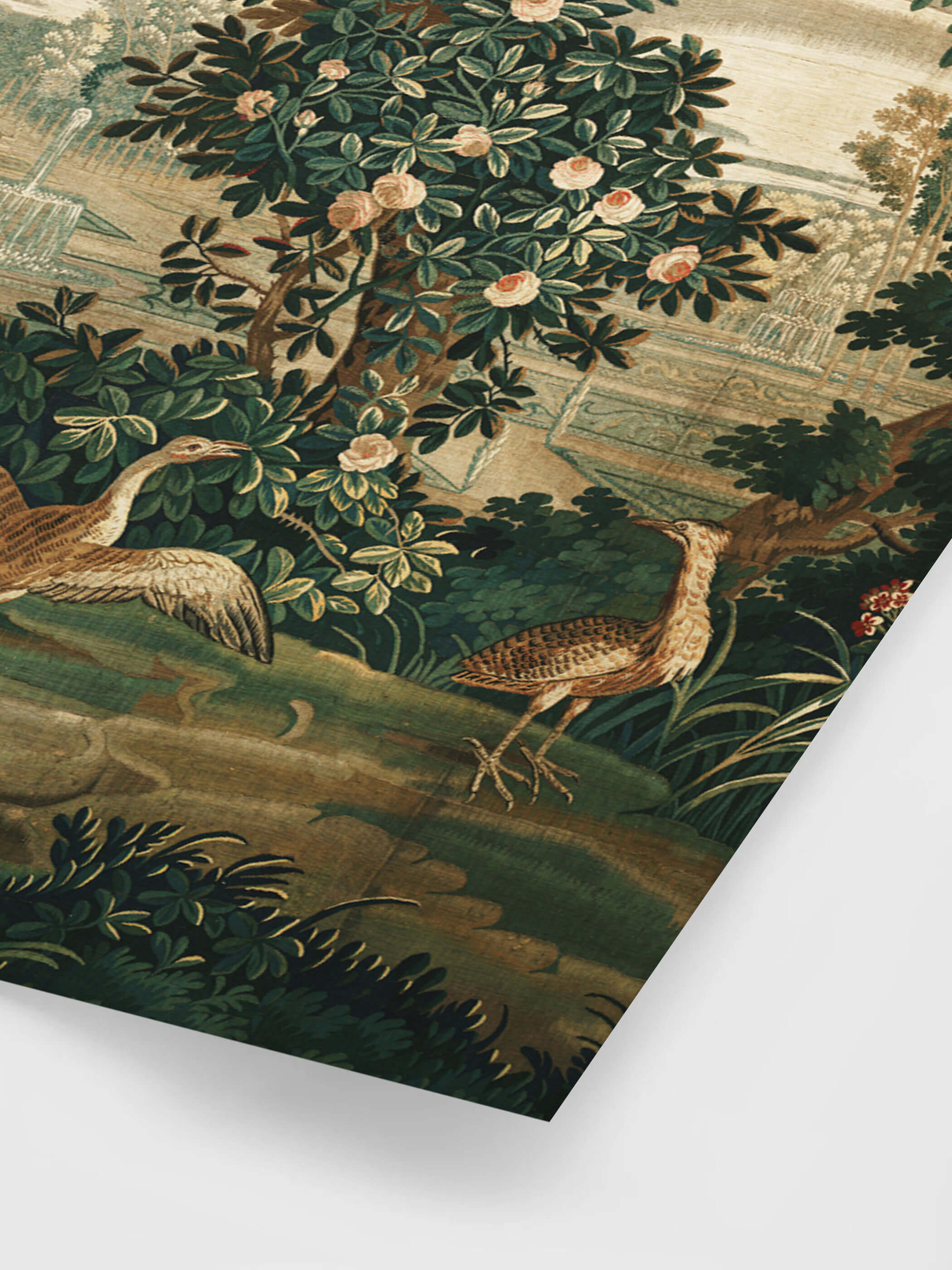 Nahaufnahme eines Vintage-Gobelins, der eine Gartenszene mit einem Baum, Rosen und Vögeln zeigt. Ein Vogel breitet seine Flügel aus, während er am Boden steht. Die Details des Stickmusters sind in satten Grün- und Brauntönen gehalten, was dem Druck Tiefe und Eleganz verleiht.