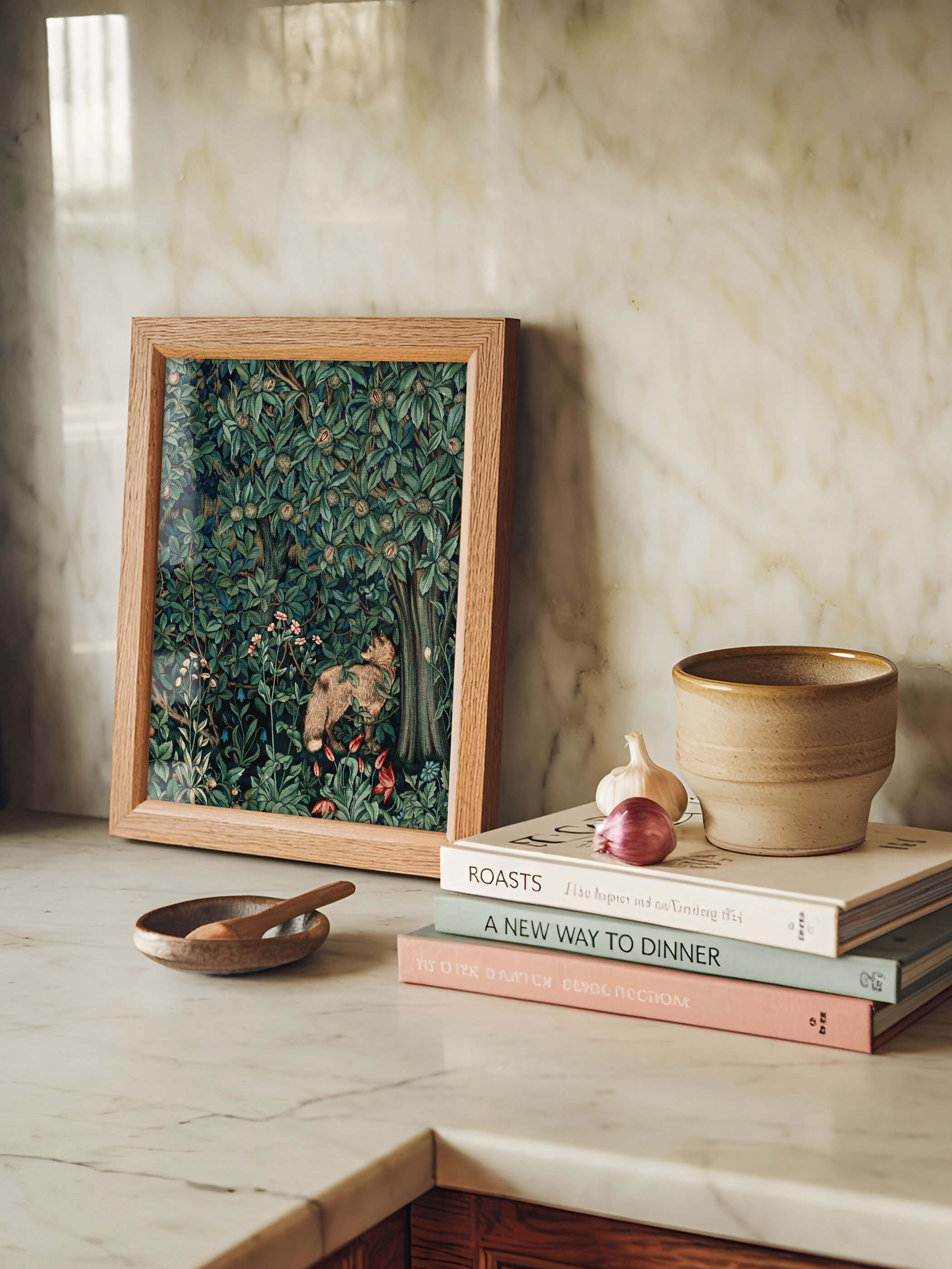 William Morris Kunstdruck mit Waldmotiv auf einem Küchenarbeitsplatte aus Marmor, dekoriert mit Büchern und einem Keramikbecher.
