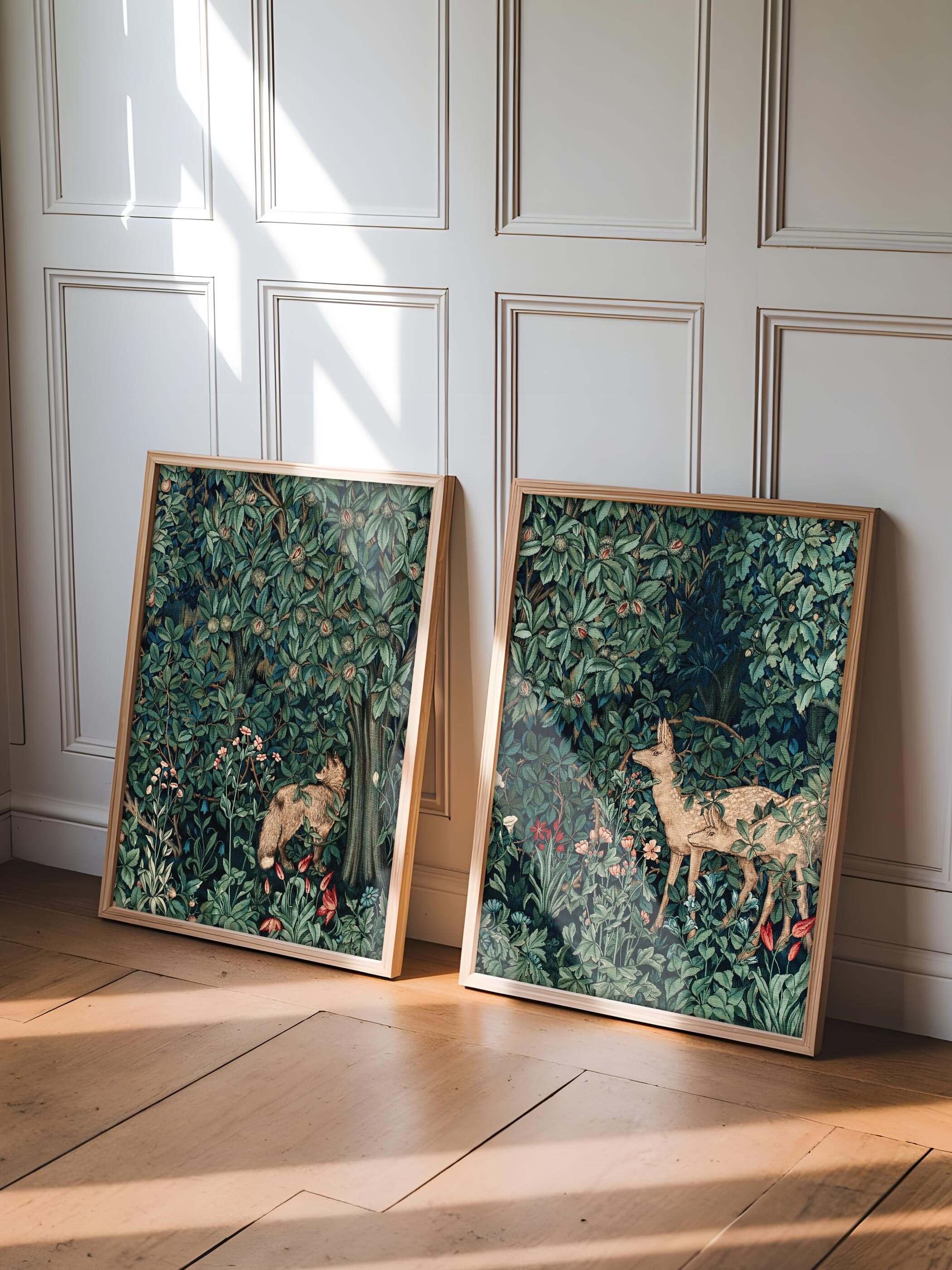 Zwei William Morris Kunstdrucke mit Waldmotiven, angelehnt an eine weiße Wand in einem hellen Raum.