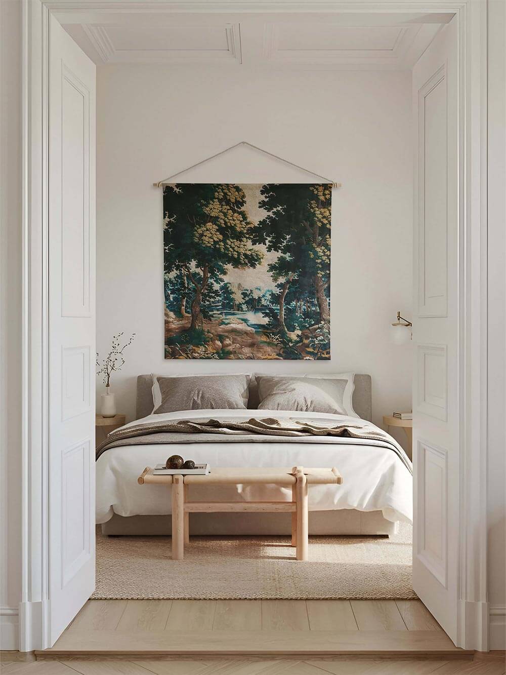 Vintage Verdure-Wandteppich über einem Bett in einem minimalistischen, neutral gehaltenen Schlafzimmer. Die dichte Waldlandschaft mit Bäumen und einem See verleiht dem Raum Tiefe und eine beruhigende, naturverbundene Atmosphäre.