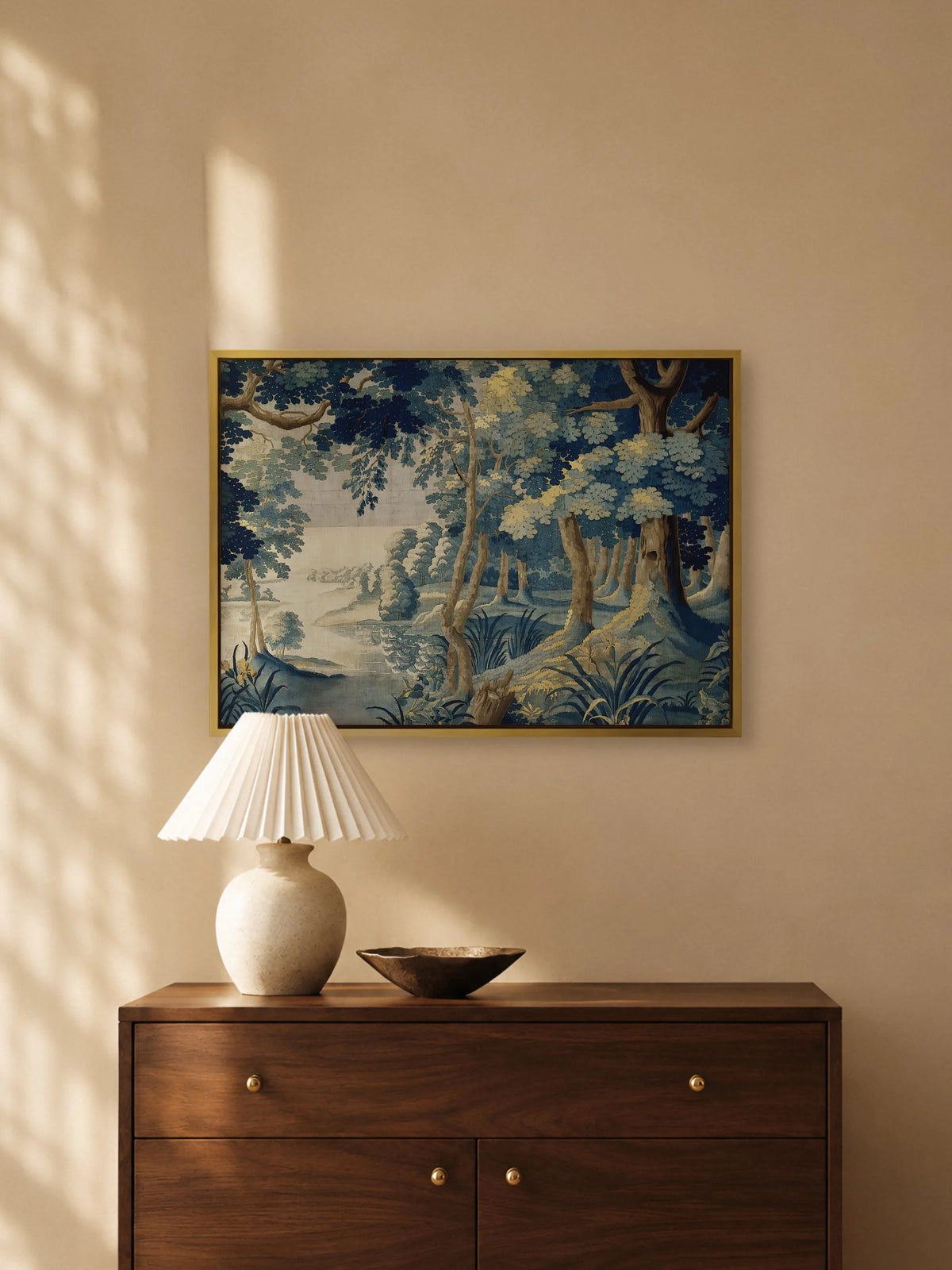 Leinwandbild mit blauem Wald im Wandteppich Stil im goldenen Rahmen über einer Kommode aus Nussbaum mit plissierter Tischlampe und Schale