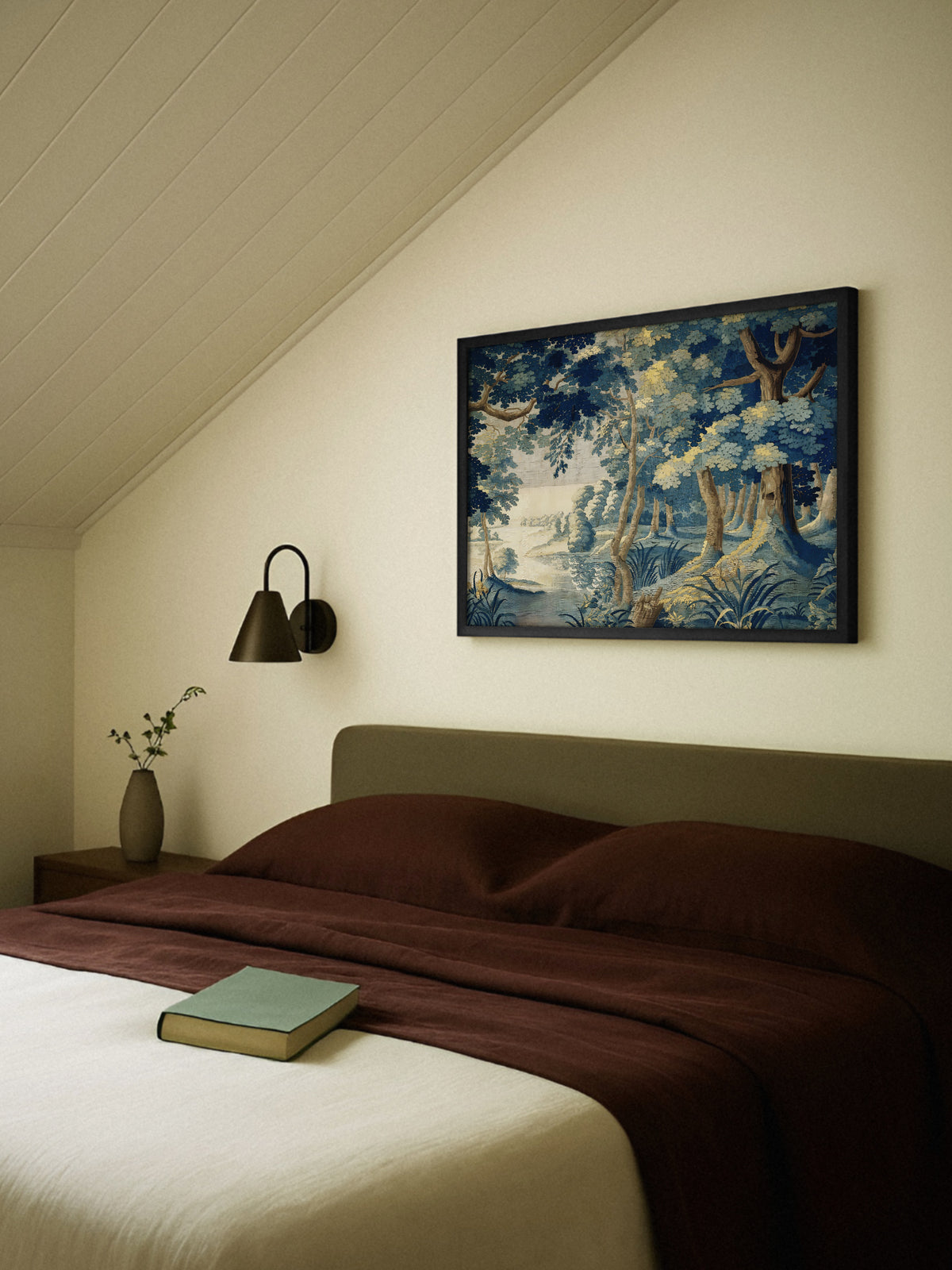 Wandbild mit Waldsee im Wandteppich Stil im schwarzen Rahmen über einem Bett mit olivgrünem Kopfteil und rotbrauner Bettwäsche unter einer Dachschräge. Daneben eine schwarze Wandleuchte und eine Vase mit Zweigen auf dem Nachttisch.