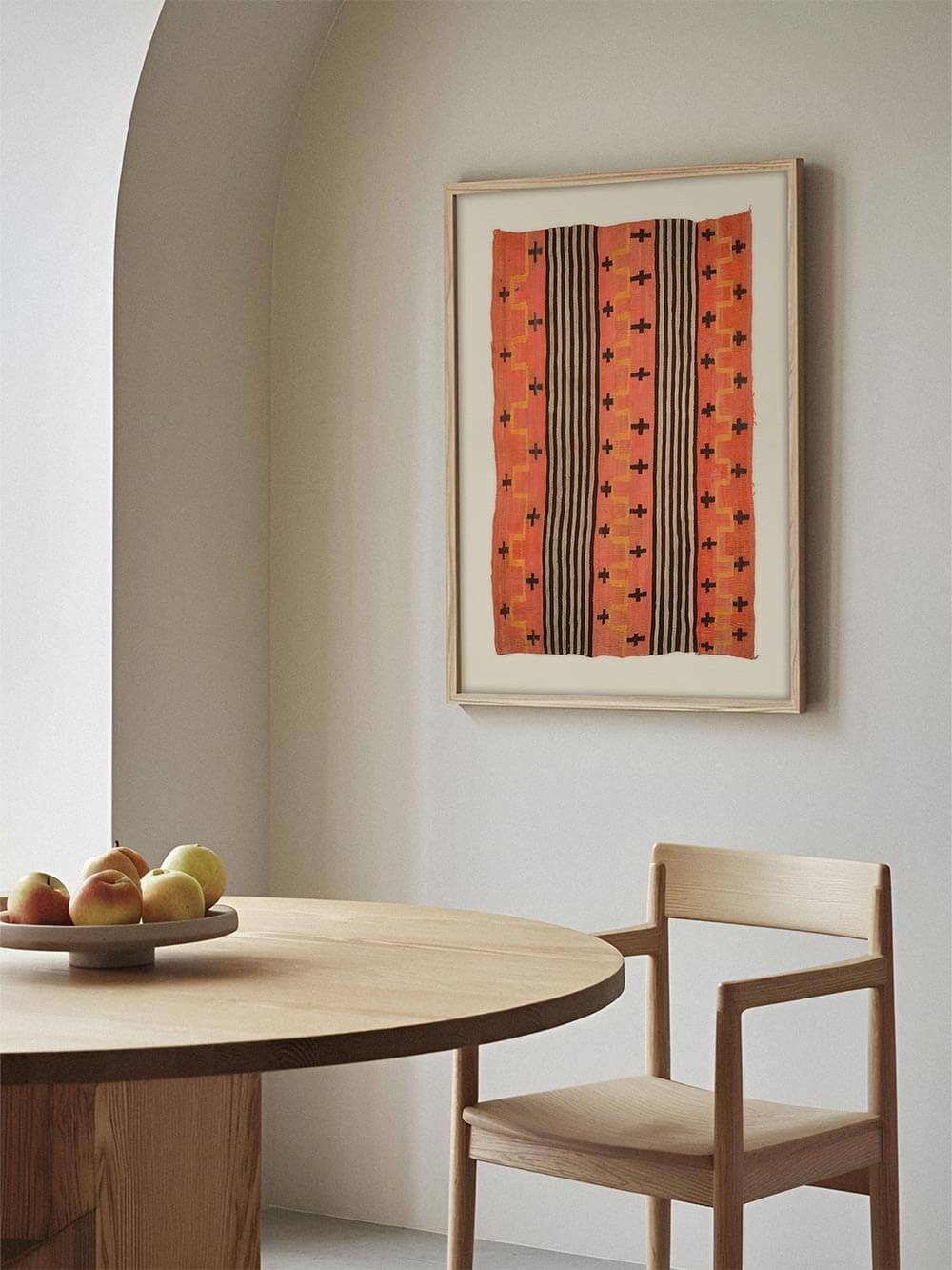 Gerahmtes Textilposter hängt in einem hellen modernen Esszimmer über einem Holztisch mit Stühlen. Das grafische Wandbild ergänzt die ruhige Architektur und schafft einen warmen Akzent für moderne Wohn- und Essbereiche.