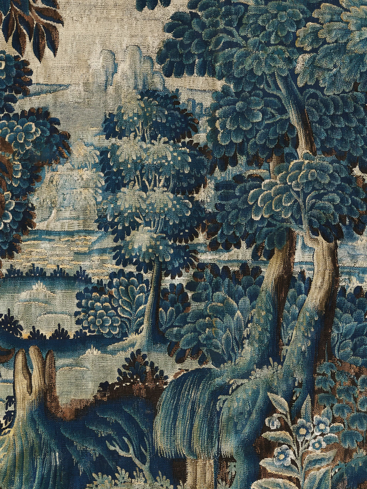 Detail des Leinwandbilds nach einer Verdure: gewebte Baumkronen in Blau und Petrol, Fluss im Hintergrund und kleine blaue Blüten